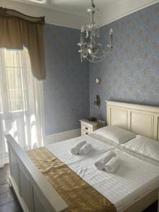 a bedroom with a large white bed with a chandelier at Apartment Hisa 7 Piran in Piran