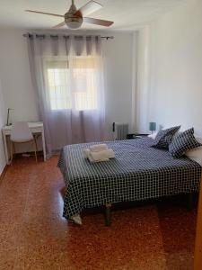 een slaapkamer met een bed en een plafondventilator bij Room Valdeolleros in Córdoba