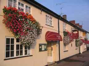 un edificio con cestas de flores a su lado en The Riverside Hotel, en Monmouth