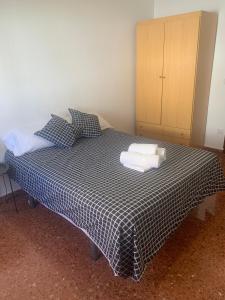 een slaapkamer met een bed met twee handdoeken erop bij Room Valdeolleros in Córdoba