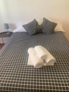 Una cama blanca y negra con dos toallas. en Room Valdeolleros, en Córdoba