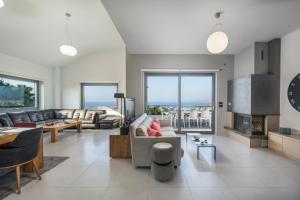 a living room with a couch and a table at Elysium Seaview Oasis in Kato Galatas