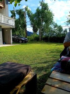 une personne assise sur un banc dans une cour dans l'établissement Tranquil Retreat - "Villa Green Oasis", à Sarajevo
