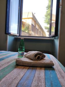 a bottle of milk sitting on a bed next to a window at Fiuggiamo House in Fiuggi