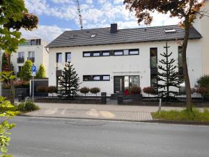 una casa blanca con ventanas negras en una calle en Willkommen Zuhause - Traumhafte, zentrale Ferienwohnung in Kurstadt, en Bad Oeynhausen