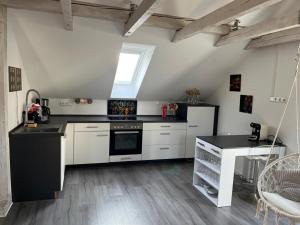eine Küche mit schwarzen und weißen Geräten und einem Tisch in der Unterkunft Willkommen Zuhause - Traumhafte, zentrale Ferienwohnung in Kurstadt in Bad Oeynhausen