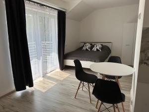 sypialnia z łóżkiem, stołem i krzesłami w obiekcie Roomflacja w Wiśle