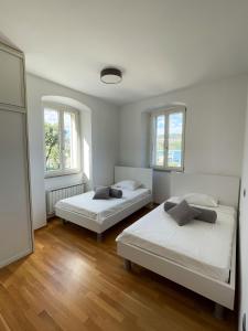 two beds in a room with two windows at Koper Sea Apartment in Koper