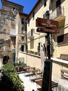 un letrero de la calle frente a un edificio con mesas y sillas en Appartamento Porta Maggio II, en Terracina