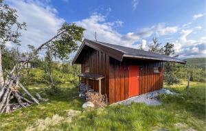 a small wooden cabin in a field of grass at Awesome Home In Reinli With Sauna And 4 Bedrooms in Reinli