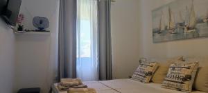 a bedroom with a bed and a window with at Apartman Campo in Šibenik