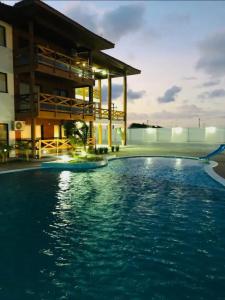 a hotel swimming pool in front of a building at FLAT 104 Luis Correia Vila Atlântida in Luis Correia