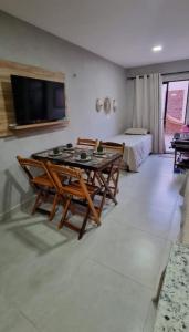 FLAT 104 Luis Correia Vila Atlântida في لويس كوريا: غرفة معيشة مع طاولة وكراسي وسرير