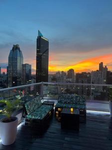 a rooftop deck with couches and a view of a city at Impressive City View Apartment A - PH Quartier Marbella in Panama City