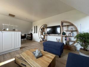 a living room with a blue couch and a table at Ferienwohnung in Wyk-Boldixum auf Foehr in Boldixum