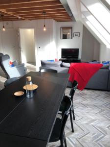 ein Wohnzimmer mit einem schwarzen Tisch und einem Sofa in der Unterkunft Gîte de Tournai-Cathédrale-Centre historique in Tournai