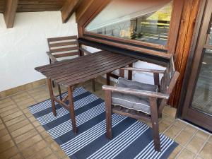un banc en bois et une chaise sur une terrasse couverte dans l'établissement FeWo Schwobaländle, 