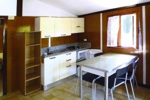 eine Küche mit einem Tisch, einem Tisch und Stühlen in der Unterkunft Holiday resort in Villanova d'Albenga in Villanova dʼAlbenga