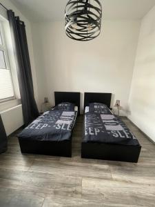 2 camas en un dormitorio con lámpara de araña en Ferienapartment Essen en Essen