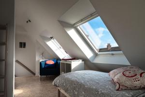 um quarto no sótão com uma cama e uma janela em Gîte de Tournai-Cathédrale-Centre historique em Tournai