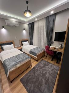 伊斯坦堡的住宿－AYD Apart Harbiye Taksim，酒店客房设有两张床、一张桌子和一台电视。