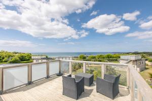 een balkon met stoelen en uitzicht op de oceaan bij Le Theven in Sibiril