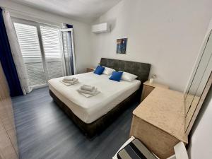 ein Schlafzimmer mit einem Bett mit blauen Kissen und einem Spiegel in der Unterkunft Apartman Gaga in Kruševo