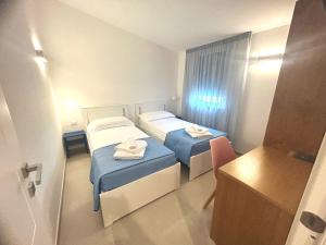 Kleines Zimmer mit 2 Betten und einem Schreibtisch. in der Unterkunft Elios Badino B&B in Terracina