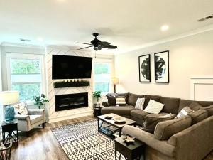 a living room with a couch and a flat screen tv at Pink Sand Hideaway in Hilton Head Island