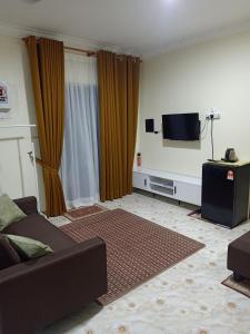 a living room with a couch and a flat screen tv at Heal Inn Roomstay - Islam Guest in Kangar