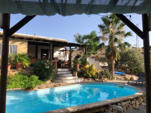 a swimming pool in front of a house at Cortijo Dos Santos in Valle de Abdalagís