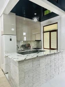 a large white kitchen with a large counter top at House in Tsikhisdziri in K'obulet'i