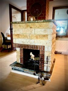 a stone fireplace in a living room with a tripod at Ferienhaus Margarete in Gablenz