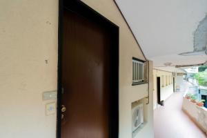 una porta marrone su un edificio con balcone di 215 - Deiva al Mare, appartamento fronte mare con vista a Deiva Marina