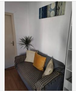un sofá con almohadas en una habitación en Loux en Lyon