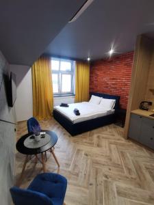 sypialnia z łóżkiem, stołem i krzesłami w obiekcie LOFT HOUSE APARTMENTS w mieście Przemyśl