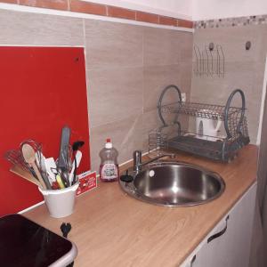 a kitchen counter with a stainless steel sink and utensils at La romance. in Prugnanes