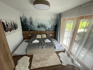a bedroom with a bed and a painting on the wall at Apartmán Snow in Oravská Lesná