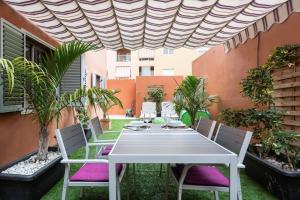 a white table and chairs on an outdoor patio at Cálido apartamento, piscina, Wi-Fi in Candelaria