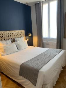 una camera da letto con un grande letto bianco con una finestra di Lumineux 2 pièces Vieil Antibes a Antibes