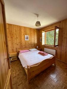 - une chambre avec un grand lit dans une pièce dotée de murs en bois dans l'établissement La casa di Fantalegno, à Camigliatello Silano