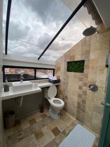een badkamer met een toilet, een wastafel en een douche bij 4a 1242BNB in Cuenca
