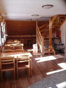 Pokój z drewnianymi stołami i krzesłami oraz schodami w obiekcie Penzion Adam - Makov w Makowie