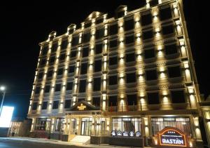 un gran edificio con luces encendidas por la noche en Dastan Grand Hotel, en Jalal-Abad
