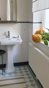 a bathroom with a sink and a radiator at TENNiS Sopot in Sopot