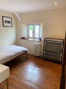 1 dormitorio con cama, ventana y radiador en Stunning Cottage Close to Amazing Beaches, en Braunton