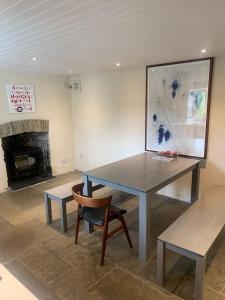 una mesa y una silla en una habitación con chimenea en Stunning Cottage Close to Amazing Beaches, en Braunton