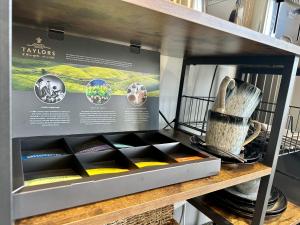uma prateleira com uma caixa cheia de diferentes placas coloridas em Priest Royd Nook - Luxury Lodgings 