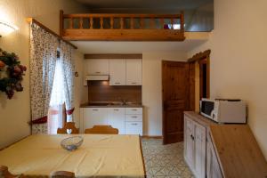 a small kitchen with a table and a microwave at Residence L'Arcobi in Livigno