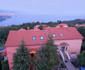 a large pink house with a red roof at Uphill Opatija Apartment in Opatija